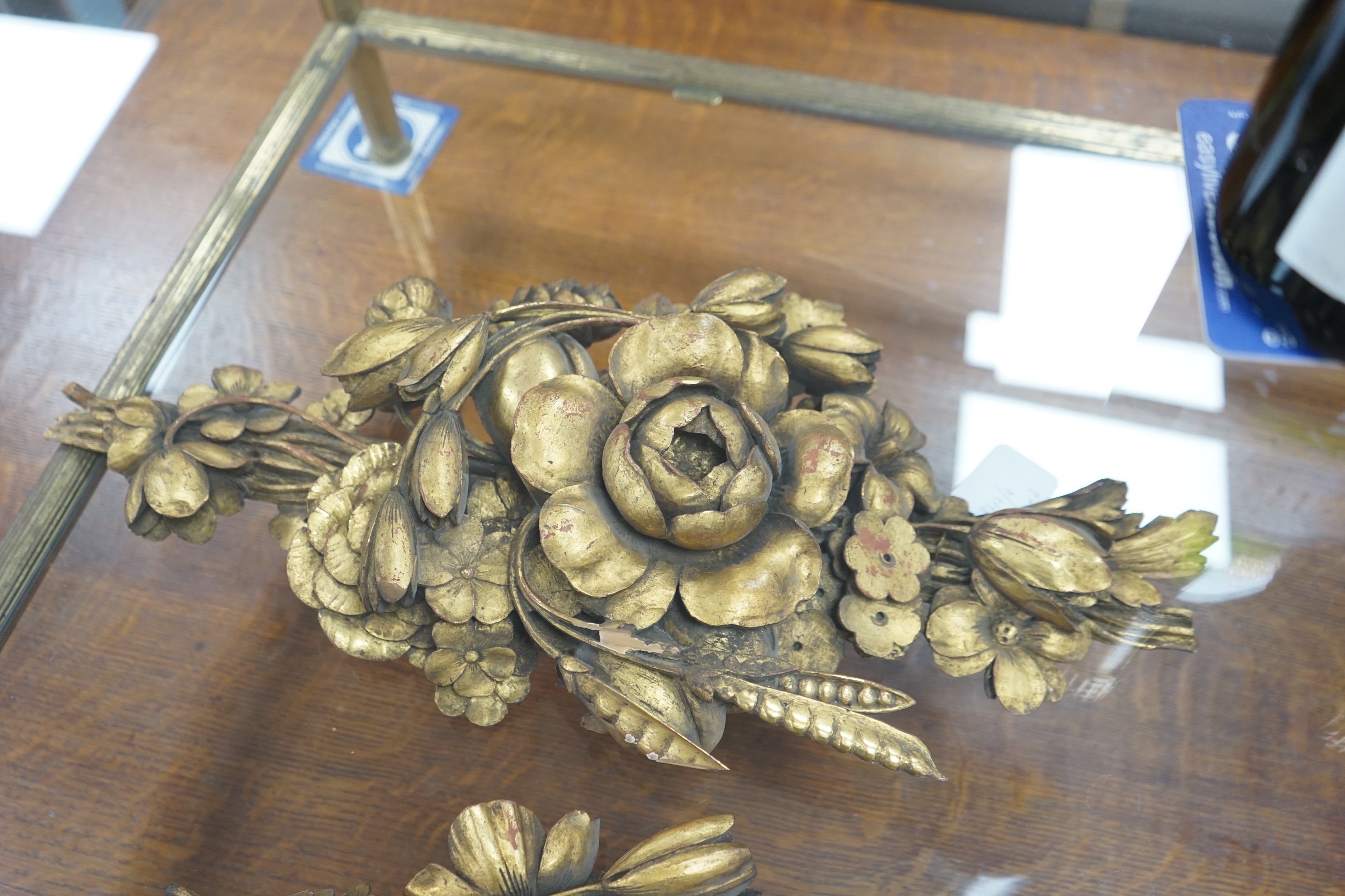 In the manner of Grinling Gibbons, two gilt carved motifs. Largest 59cm wide